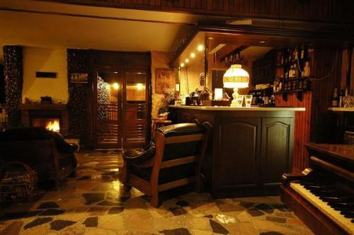 een pub met een piano en een bar met een piano bij Zajazd u Kmity in Postołów