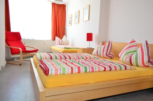 - une chambre avec un grand lit et des oreillers colorés dans l'établissement Ferienwohnung Zentrum/Hauptbahnhof, à Leipzig