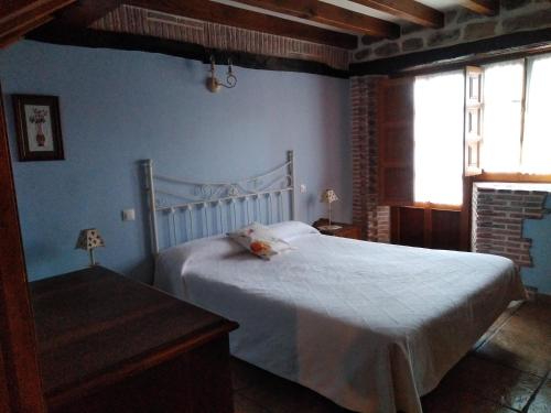 1 dormitorio con 1 cama blanca y paredes azules en Los Mantos - Vivienda Rurales, en Ibio