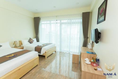 Una cama o camas en una habitación de Nam A Hotel