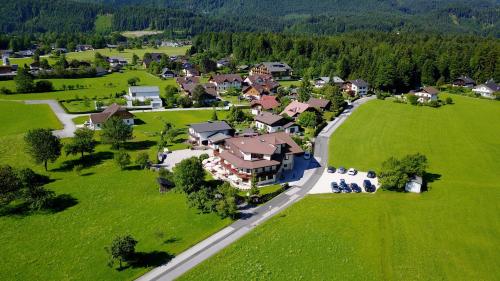 an aerial view of a house in a green field at Pension Schlömmer in Sankt Gilgen