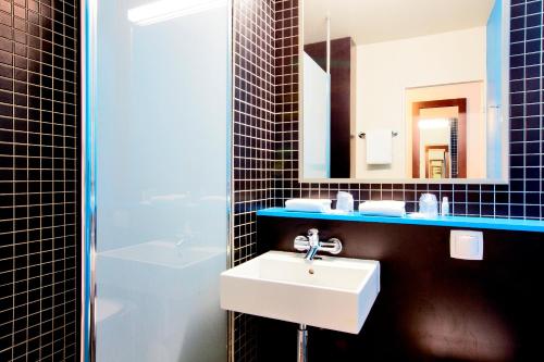 La salle de bains est pourvue d'un lavabo et d'un miroir. dans l'établissement Kyriad Viry-Chatillon, à Viry-Châtillon