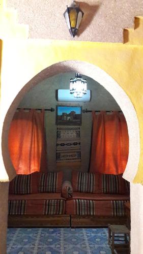 a living room with a couch in an archway at Maison Mirage B&B in Hassilabied