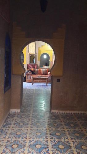 a living room with a couch in an arch way at Maison Mirage B&B in Hassilabied