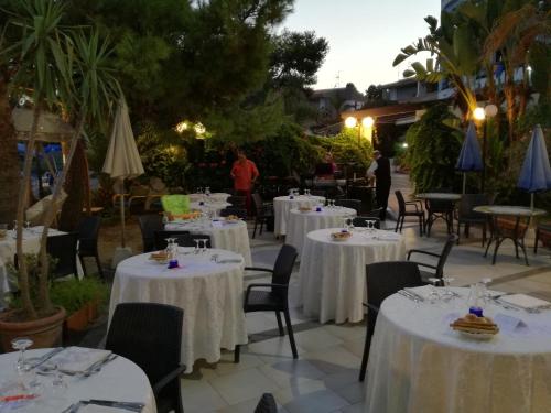 a restaurant with tables and chairs with white table cloths at Hotel Nike in Giardini Naxos