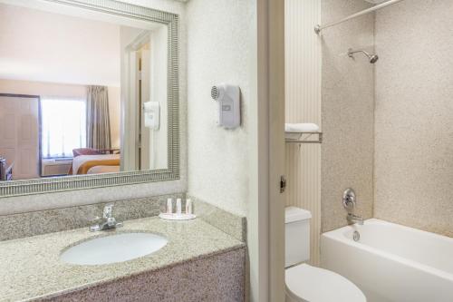 a bathroom with a sink and a toilet and a mirror at Onley Inn in Onley