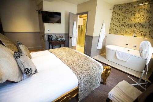 a bedroom with a large bed and a bath tub at The Cardinals Hat in Worcester