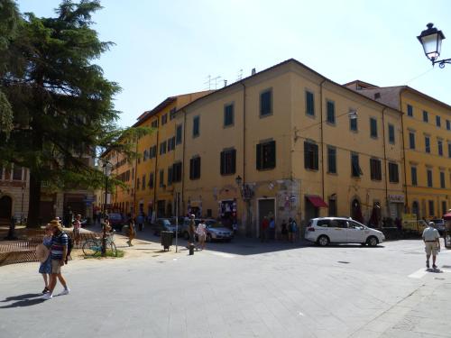 a group of people walking around a street with a building at Time Out in Pisa