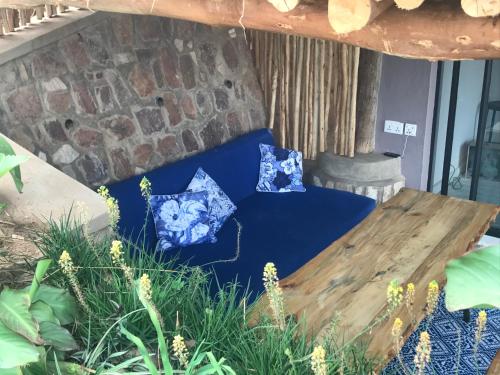 a room with a blue couch and a wooden table at Pili Pili Boutique Hotel in Kigali