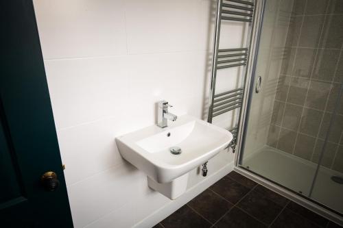 a bathroom with a white sink and a shower at The Cardinals Hat in Worcester