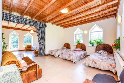 a room with two beds and a couch and windows at Neries Vila in Liucionys