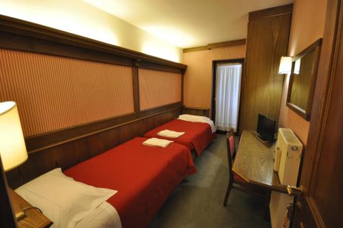ガッリオにあるHotel La Lepre Biancaのベッド2台とテレビが備わるホテルルームです。