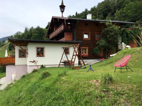 a house with a playground in front of it at Untersteinhof in Mittersill