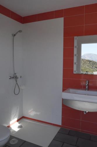 a bathroom with a toilet and a sink and a window at Villa Rural El Mirador in Alora