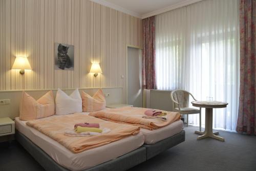 una camera da letto con un grande letto con due bambole sopra di Hotel Thüringer Wald a Ilmenau