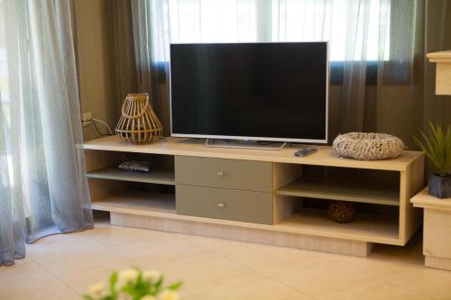 a television on a wooden stand in a living room at Mezonetes Toroni in Toroni