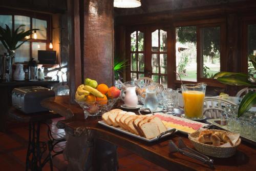 un tavolo con un vassoio di pane, frutta e succo d'arancia di Ñande Retá a Colonia Carlos Pellegrini