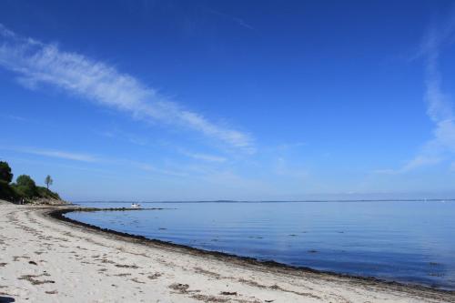 a beach with a blue sky and the water at Lindenhof Habernis in Steinberg