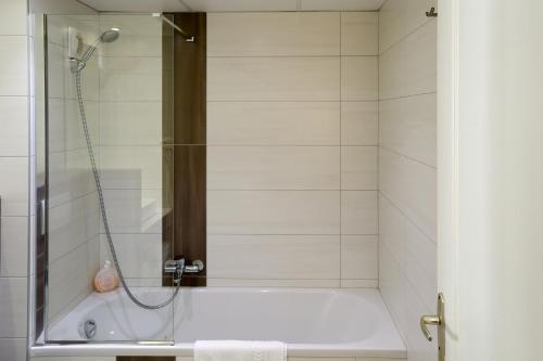 a bathroom with a shower and a bath tub at ibis Styles Carcassonne La Cité in Carcassonne