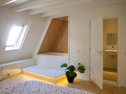a bedroom with a tub and a potted plant at Bed & Breakfast Glimmen in Glimmen