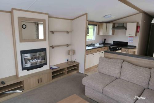 a living room with a couch and a kitchen at West Loch Shores in Tarbert