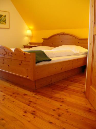 a large wooden bed in a room with a wooden floor at Gasthof Stegweber in Schwanberg
