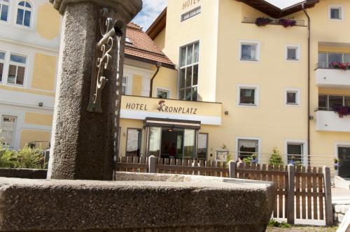 a building with a wooden fence in front of a building at Hotel Kronplatz in Valdaora