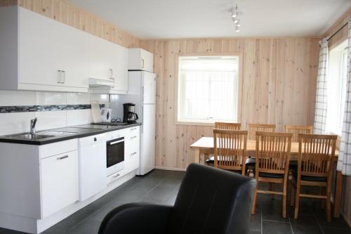 een keuken en eetkamer met een tafel en stoelen bij Tråsåvika Camping in Viggja