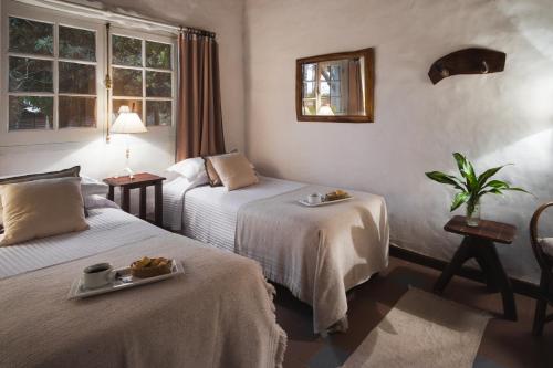 a hotel room with two beds with a tray of food at Ñande Retá in Colonia Carlos Pellegrini