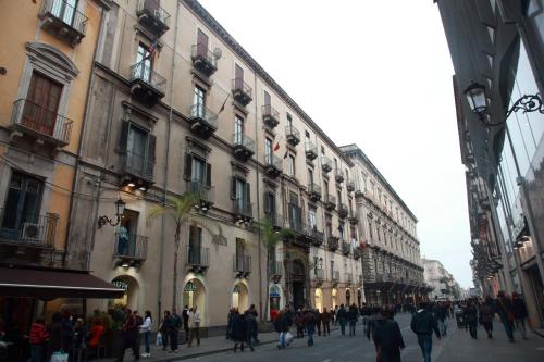 un grupo de personas caminando por una calle frente a los edificios en B&B Alba, en Catania