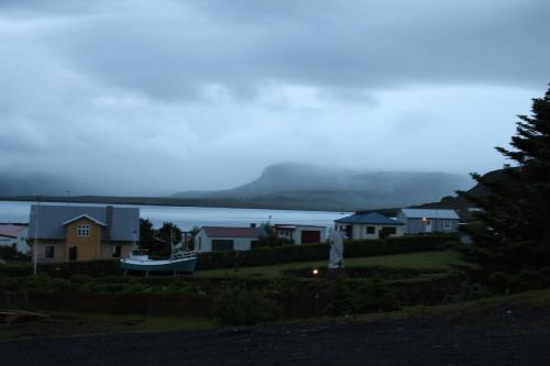 a view of a house with a mountain in the background at North Star Guesthouse Olafsvik in Ólafsvík