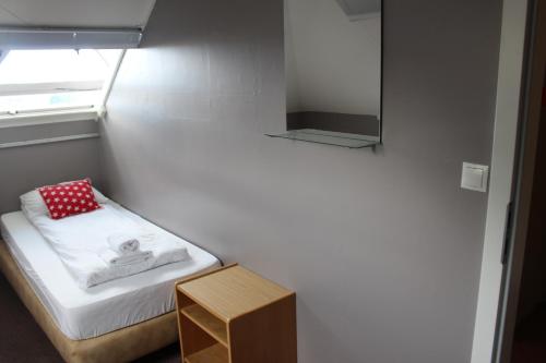 a small room with a small bed and a mirror at North Star Guesthouse Olafsvik in Ólafsvík