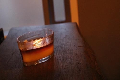 a glass of tea sitting on a wooden table at North Star Guesthouse Olafsvik in Ólafsvík