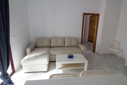 a living room with a couch and a table at Apartamentos Centro 1 El Puerto de Santa Maria in El Puerto de Santa María