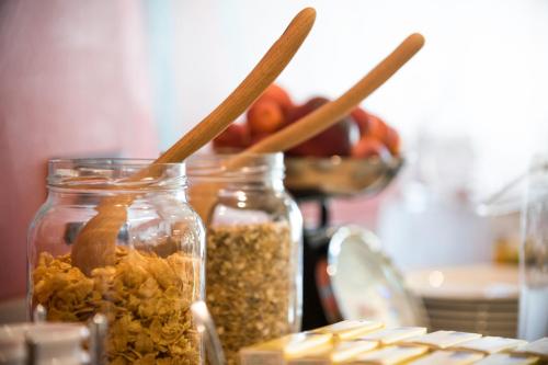 two glass jars filled with seeds and a bowl of apples at ibis Styles Carcassonne La Cité in Carcassonne