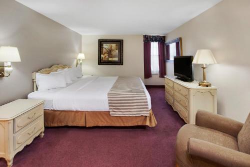 スーセントマリーにあるThe Hotel Ojibway, Trademark Collection by Wyndhamのベッドルーム(大型ベッド1台、ソファ付)