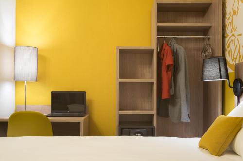 a bedroom with a bed and a desk and a closet at ibis Styles Carcassonne La Cité in Carcassonne