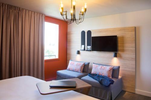 a hotel room with a bed and a couch at ibis Styles Carcassonne La Cité in Carcassonne