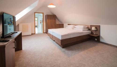 a bedroom with a bed and a flat screen tv at Hotel am Wasen in Freiberg am Neckar