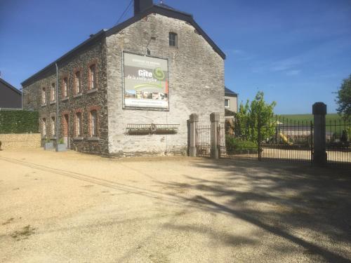 a brick building with a sign on the side of it at Le gîte de la vieille église in Tenneville