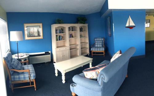 a living room with blue walls and blue furniture at Riverview Resort in South Yarmouth