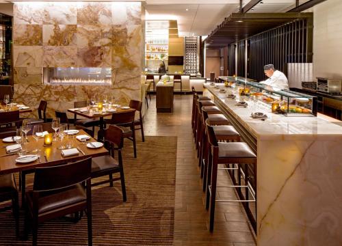 a restaurant with tables and a chef preparing food at Hyatt Regency Chicago in Chicago