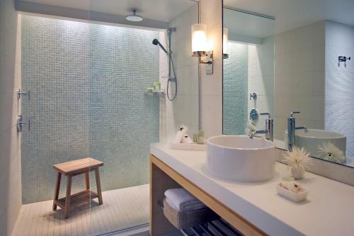 a bathroom with a tub, sink and mirror at Hyatt Centric Key West Resort & Spa in Key West
