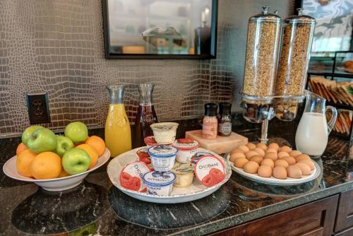 a counter with plates of fruit and eggs on it at Garrison Hotel & Suites Dover-Portsmouth, an Ascend Collection Hotel in Dover