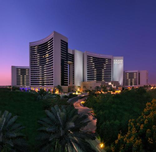 
a large city with tall buildings and palm trees at Grand Hyatt Dubai in Dubai
