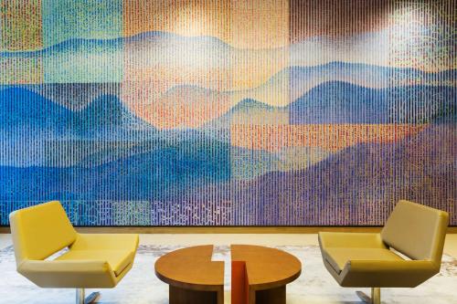 two chairs and a table in front of a painting at Hyatt Place Shenzhen Dongmen in Shenzhen