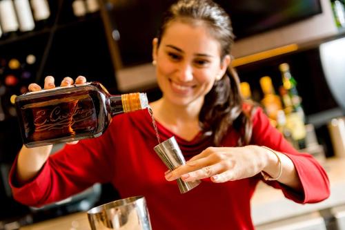 a woman pouring a bottle of wine into a glass at Hyatt Place Sao Jose do Rio Preto in Sao Jose do Rio Preto