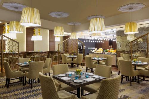 una sala da pranzo con tavoli, sedie e lampadari di Jabal Omar Hyatt Regency Makkah a La Mecca