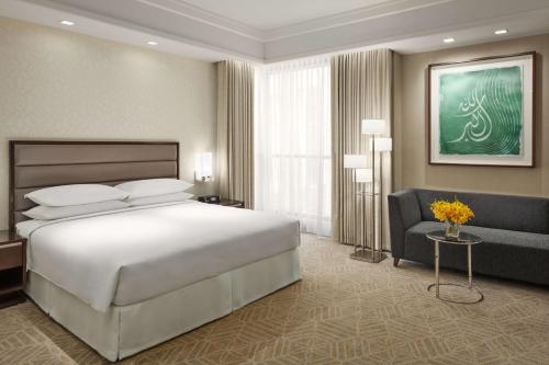 a bedroom with a large white bed and a couch at Jabal Omar Hyatt Regency Makkah in Makkah