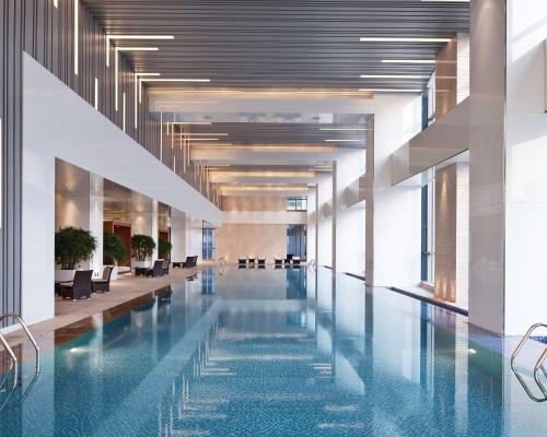 a large swimming pool in a building with a lobby at Hyatt Regency Jinan in Jinan